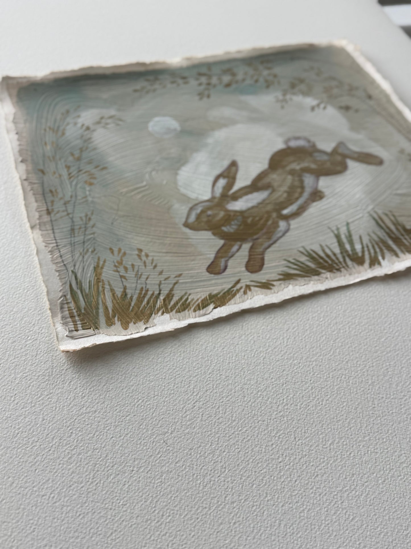 "Bounding Bunny" painting on handmade paper of a rabbit jumping