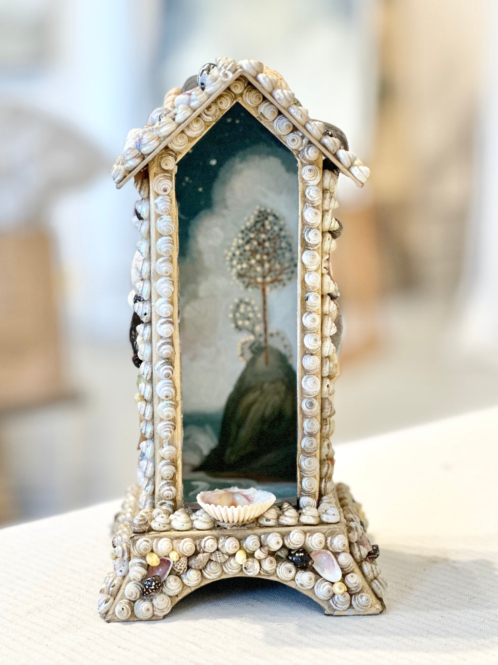 "Reliquary for Otherland" shrine like house of seashells with seascape painted inside